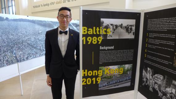 Iverson Ng stands beside his exhibit comparing the Baltics in 1989 and Hong Kong in 2019.