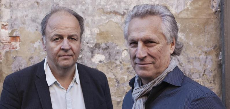 Henrik Berggren and Lars Trägårdh pose before a brick wall.