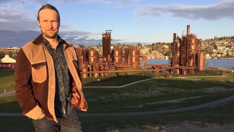 Toni Lahtinen stares into the setting sun, which casts a golden glow on the rusted, industrial detritus of Gas Works Parks.
