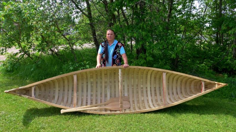 Wayne Valliere with a birchbark canoe.
