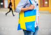 University man walking with bag, bag emblazoned with Swedish flag